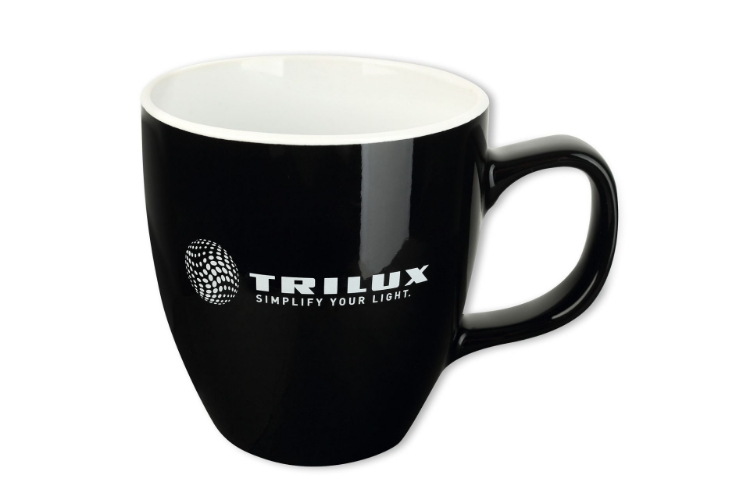 Schwarze Tasse von außen, Innen weiß. Vorderseite weißes TRILUX-Logo