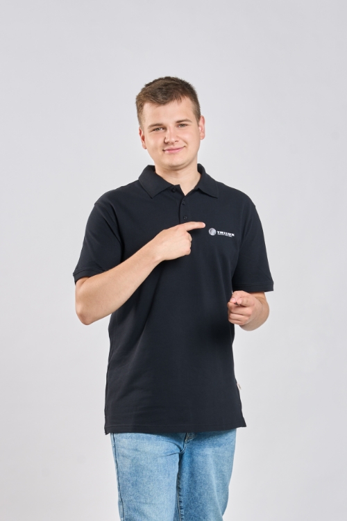 Männliches Model trägt Schwarzes Poloshirt mit drei schwarzen Knöpfen, weißes TRILUX Logo auf linker Brust